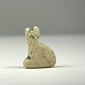 Small faience Bastet amulet from Ancient Egypt with textured earthen deposits and surviving areas of blue-green glazing.