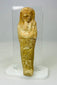 Weathered Late Period Egyptian ushabti with mineral deposits on a neutral background