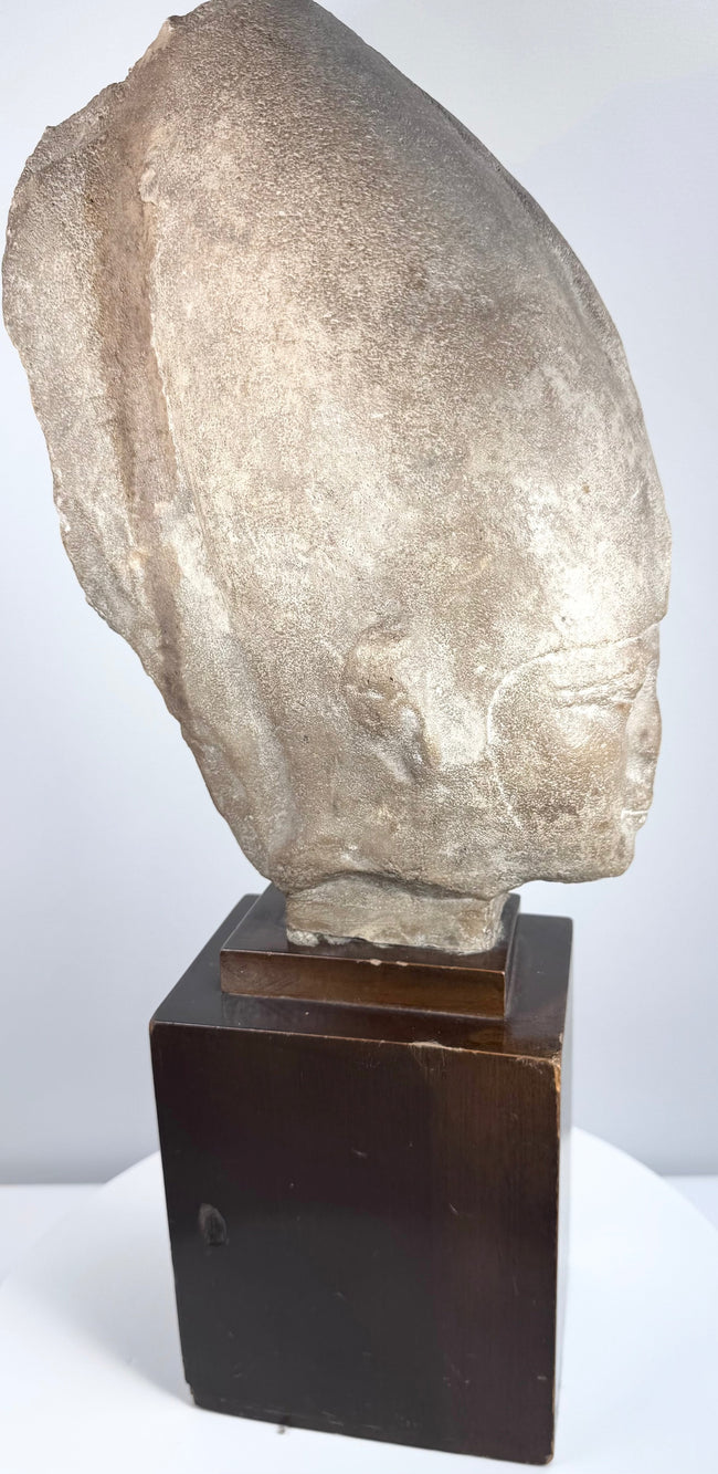 Full-length view of the substantial Egyptian-inspired royal head and its original display presentation