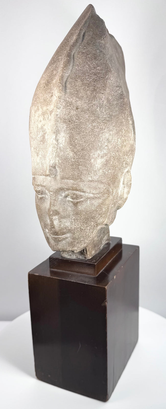 Side view of the Egyptian Revival pharaoh head showing its tall White Crown and hardwood base