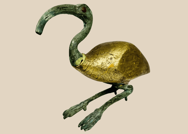 Egyptian Revival sacred ibis sculpture crafted from mixed media with a gilt body and verdigris-patinated neck and legs.