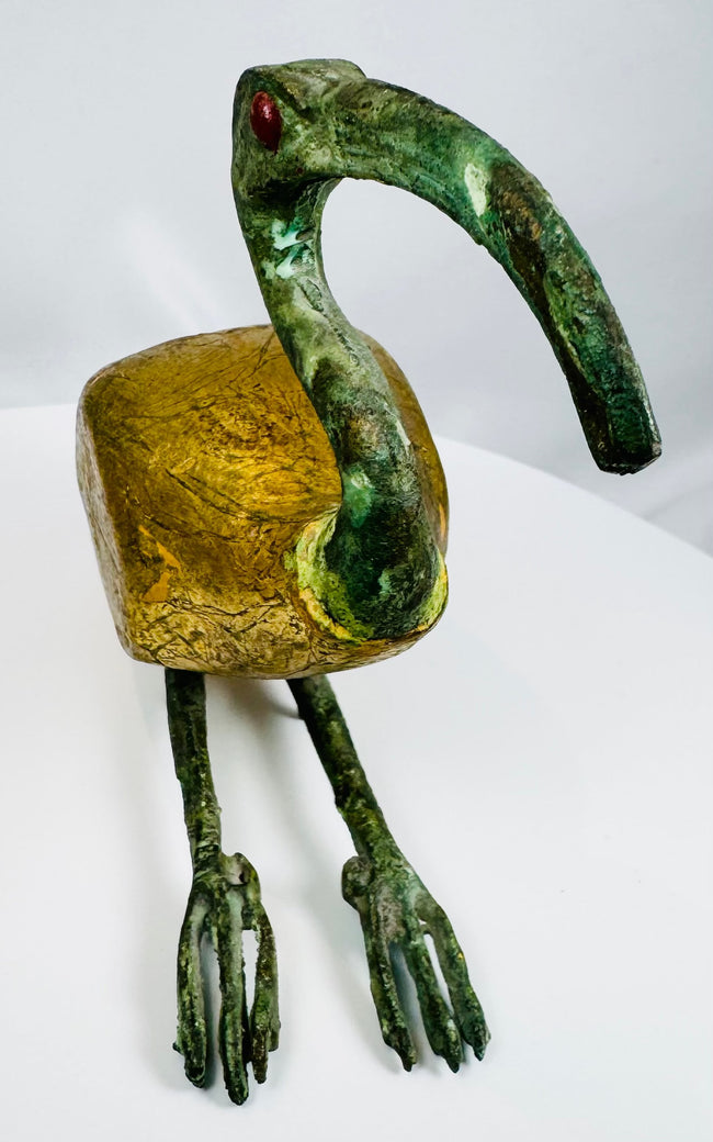 Vintage sacred ibis sculpture inspired by ancient Egyptian art with a textured gold-colored body and patinated neck.