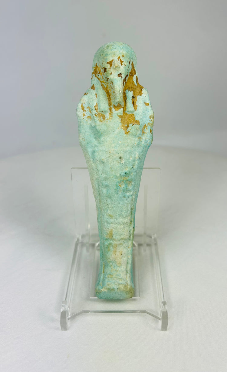 Ancient Egyptian turquoise-blue faience Ushabti standing on a clear display base against a white background