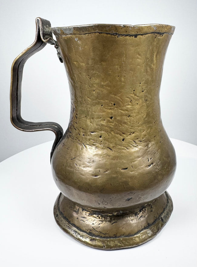 Georgian brass baluster tankard from England with decorative stepped foot, broad body, and traditional handle design.