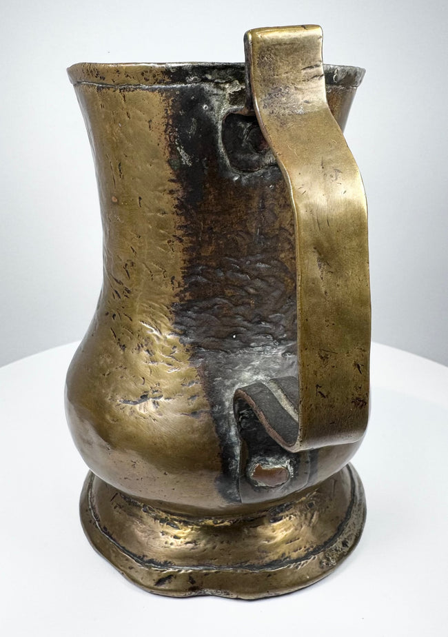English 18th-century brass ale tankard showing traditional Georgian craftsmanship, cylindrical body, and decorative footed base.