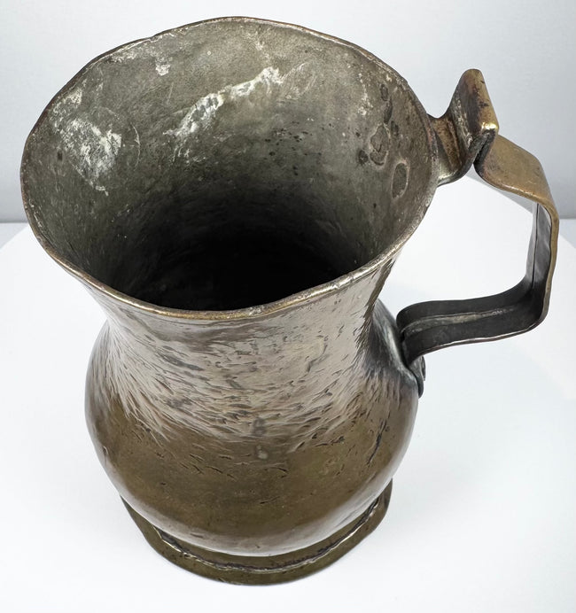 George II English brass tankard showing the aged interior, flared mouth, and natural patina developed over centuries.