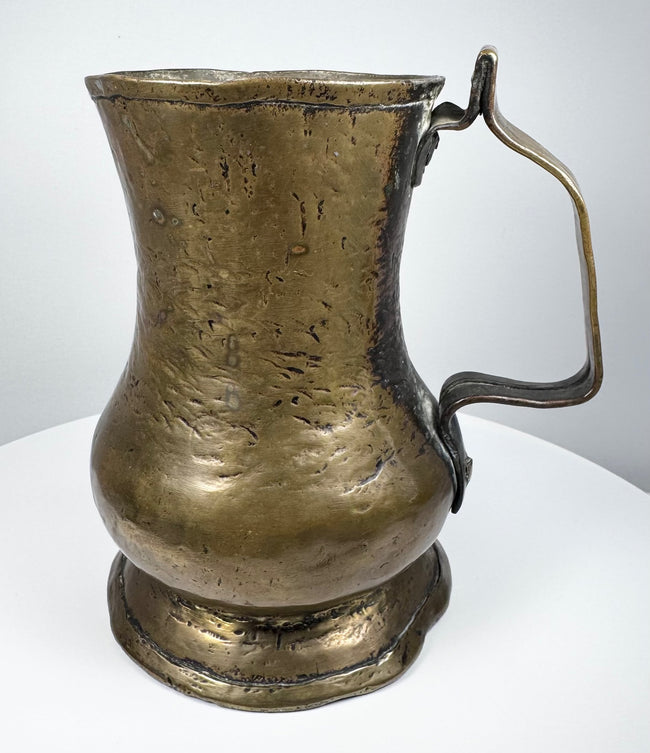18th-century English George II brass baluster tankard, circa 1727–1760, with aged golden patina and single handle.