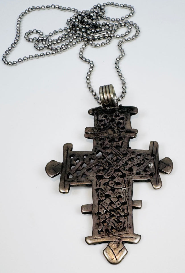 Vintage Ethiopian Christian cross in silver-tone metal displaying traditional Orthodox openwork design.