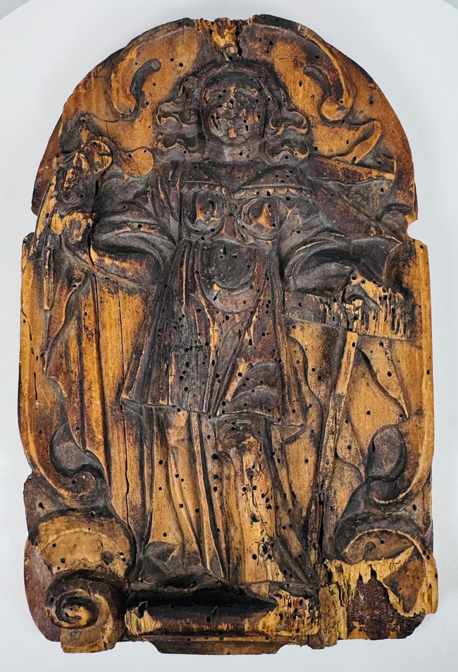 Reverse of an antique wooden religious relief showing the later backing panel and metal hanging bracket