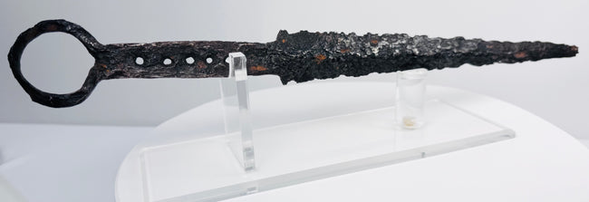 Detailed view of medieval quillon dagger with ring pommel, aged iron surface and tapered fighting blade