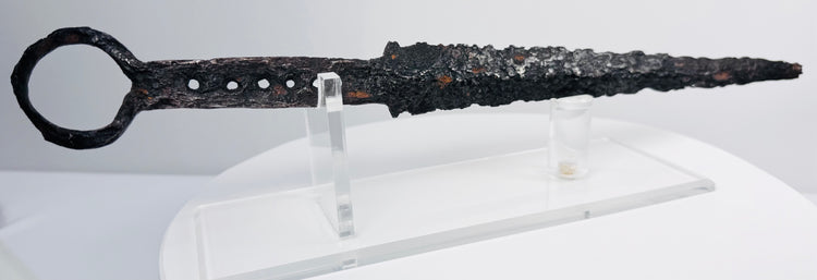 Detailed view of medieval quillon dagger with ring pommel, aged iron surface and tapered fighting blade