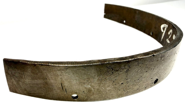 Perspective shot of thick-rimmed historical steel armor piece with wear marks and numbering