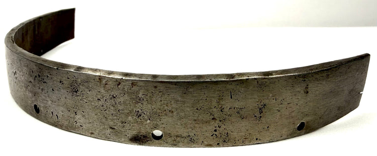 Close-up of 17th-century defensive steel band with pitted surface and squared ends