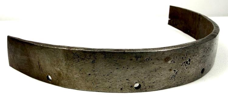 Angled view of heavy curved steel siege armor segment showing convex shape and attachment points