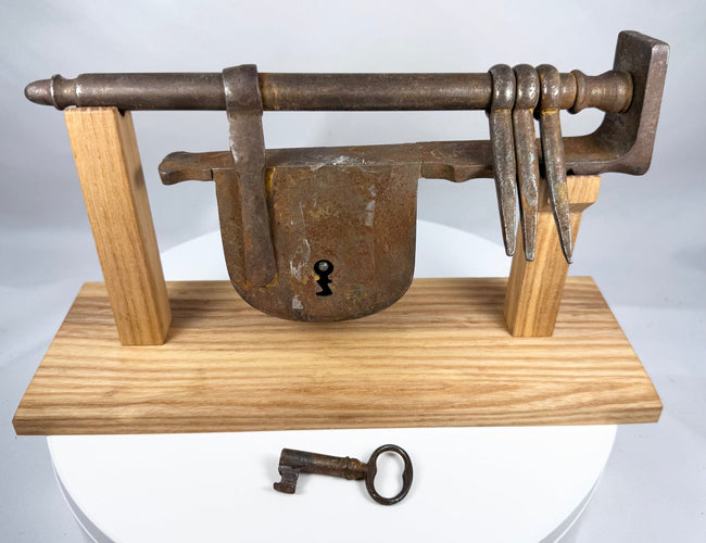 Historic wrought-iron gate lock showing its long security bar and shaped end finial