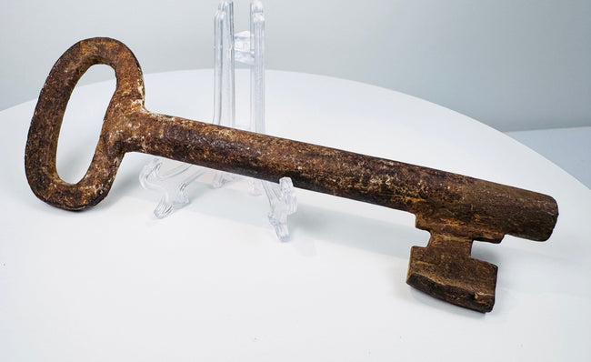 Historic 18th-century iron key with oval handle and traditional warded-lock design.
