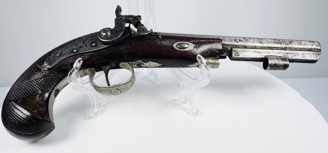 Historic British percussion sidearm with octagonal barrel, engraved fittings and checkered wooden grip