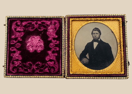 Mid-19th-century cased photographic portrait of a formally dressed gentleman with gilt-metal mat and burgundy velvet lining