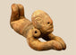 Pre-Columbian terracotta prone human figure in the coastal Ecuadorian sculptural tradition, featuring raised legs and prominent circular earspools, circa 500 BCE–500 CE.