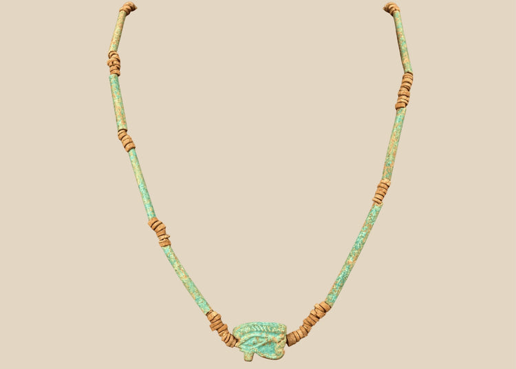Ancient Egyptian Eye of Horus faience necklace with turquoise-green tubular beads and earthy brown spacer beads, circa 664–30 BCE.