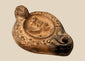 Ancient Roman terracotta oil lamp with ithyphallic male figure in central relief, circa 2nd century CE, featuring elaborate moulded decoration.
