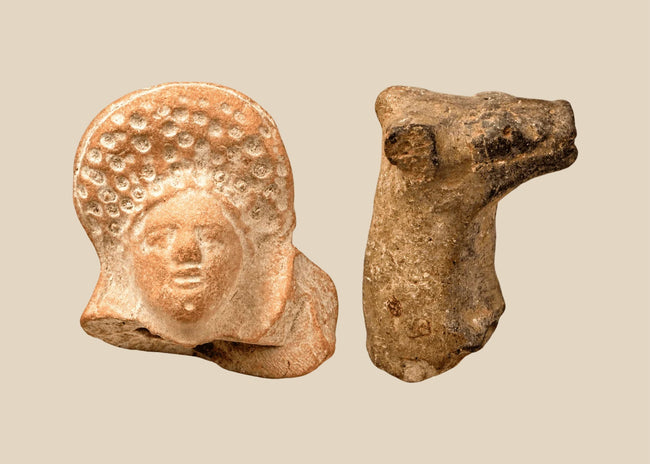 Ancient Roman terracotta female head with elaborate curled coiffure alongside an Early Bronze Age Mesopotamian bovine protome.