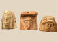 Three ancient Greek terracotta female protomai from the Archaic–Classical periods, circa 6th–4th century BCE, featuring distinctive headdresses and sculpted faces.