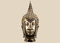 Large Thai Buddha head in Sukhothai style with serene facial features, spiral hair curls, and a tall flame-shaped finial.