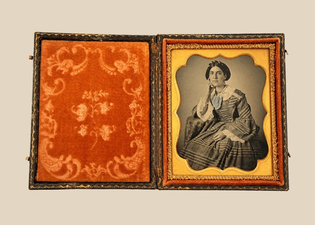 Mid-19th-century American cased photographic portrait of a seated Victorian woman wearing an elegant striped gown, circa 1850–1865.