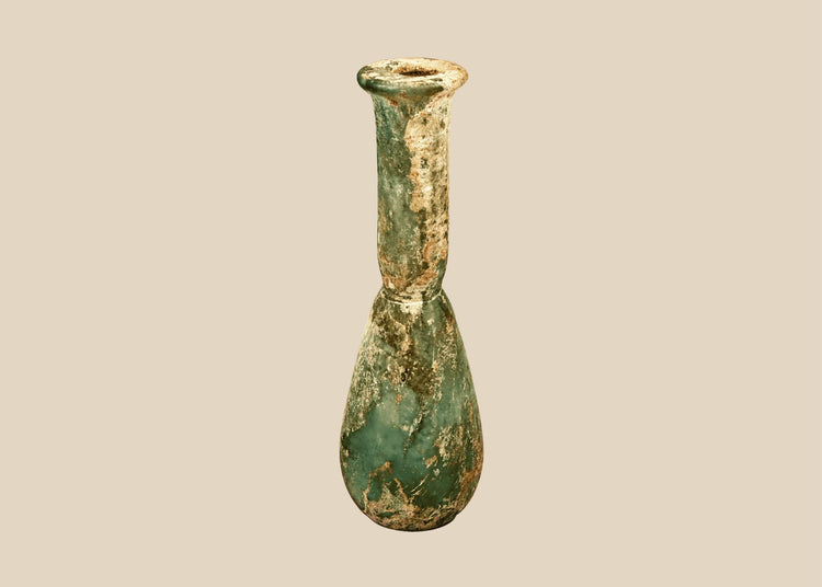 Ancient Roman green glass unguentarium with a pear-shaped body, elongated neck, and flared circular rim, circa 1st–4th century CE.