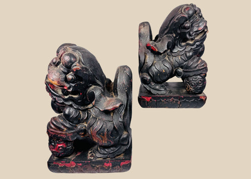 Antique Chinese Qing Dynasty wooden guardian lion pair with dark lacquer, red pigment and carved brocade balls