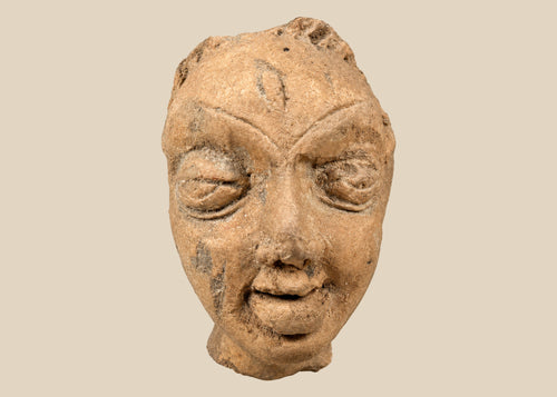 Gupta-period Northern Indian terracotta head fragment with serene almond-shaped eyes, arched brows, and softly smiling lips, warm earthen tones with mineral deposits, 3rd–5th century CE, mounted on modern display stand for preservation.