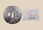 Antique Japanese iron tsuba with mixed-metal sage and spider design displayed beside its Japanese purchase receipt