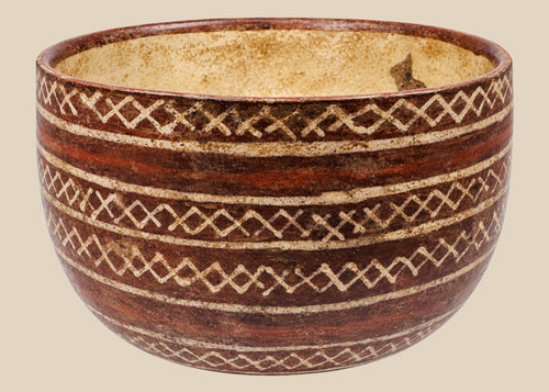 Red-brown ceramic bowl with cream interlocking diamond patterns and horizontal bands