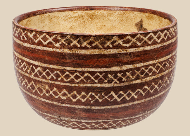 Red-brown ceramic bowl with cream interlocking diamond patterns and horizontal bands
