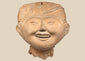 Pre-Columbian Veracruz Sonriente smiling face terracotta head with scroll-motif headdress, circa 600–900 CE