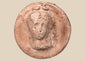 Hellenistic Greek terracotta female bust medallion with frontal portrait and aged pinkish-buff surface.