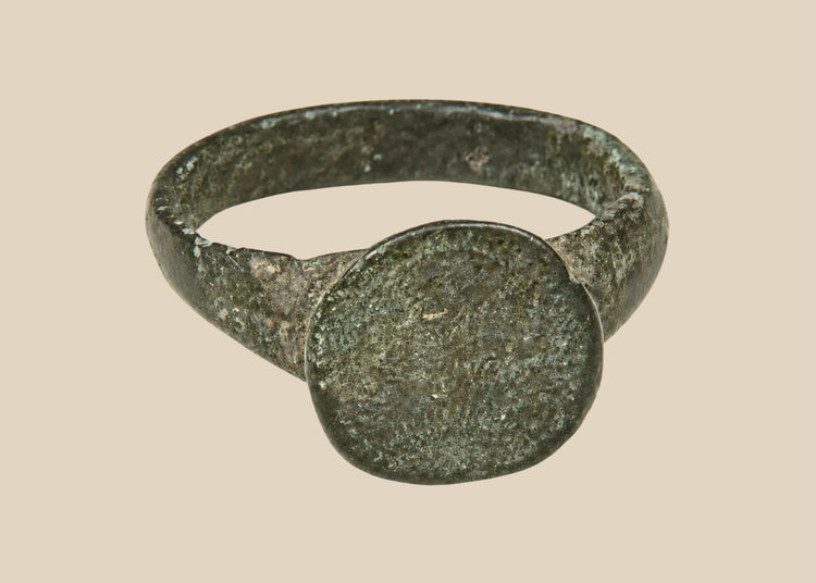 Ancient Roman–Byzantine bronze finger ring with broad circular bezel and dark olive-green patina, circa 1st–8th century CE