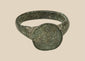 Ancient Roman–Byzantine bronze finger ring with broad circular bezel and dark olive-green patina, circa 1st–8th century CE
