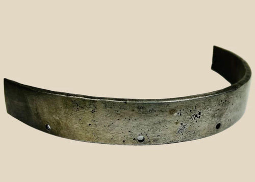 17th-century European siege armour forged steel band, curved protective element with rivet holes and aged patina from historic use.