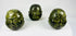 Set of three cast metal Buddhist heads with green patina in traditional brocade box