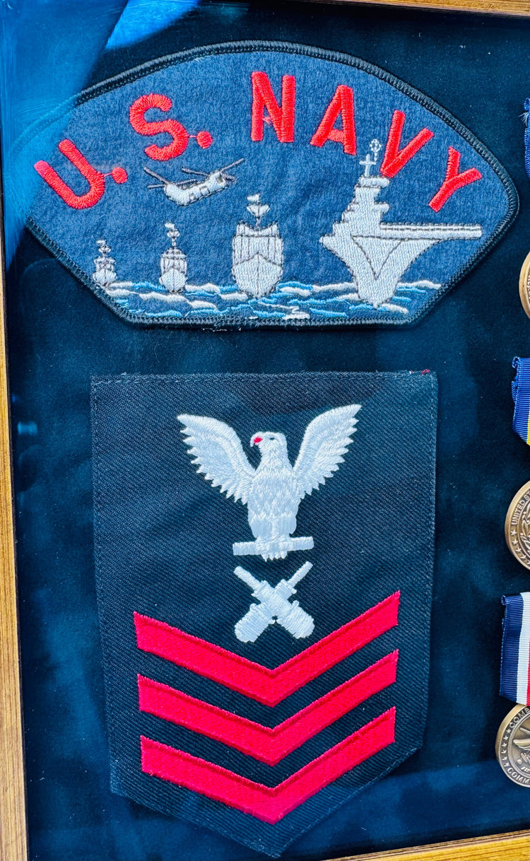 U.S. Navy military memorabilia display with USS Norris DD-859 insignia and service medals