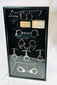 Framed display of antique handcuffs, shackles, and restraint devices from the 19th–20th century, mounted in a glass shadow box with plaques and keys.