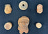 Museum-style presentation of ancient Mesoamerican artifacts in a black shadowbox