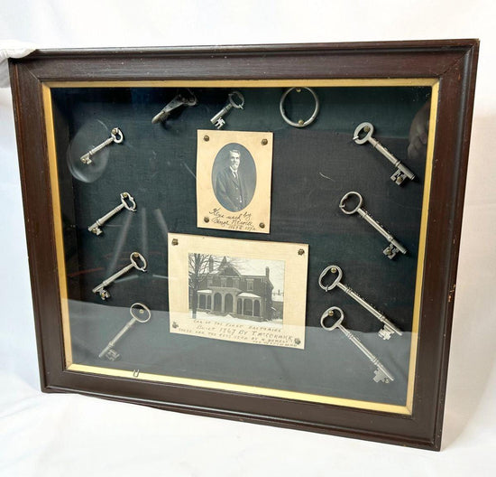 Framed 19th-century display with eleven iron keys, portrait of night watchman Hugh Newell, and early photograph of T. McCormick’s 1867 factory, preserved in a wooden shadowbox.