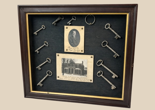 Framed 19th-century display with eleven iron keys, portrait of night watchman Hugh Newell, and early photograph of T. McCormick’s 1867 factory, preserved in a wooden shadowbox.