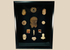 Framed collection of Pre-Columbian terracotta artifacts displayed on a black background