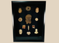 Framed collection of Pre-Columbian terracotta artifacts displayed on a black background