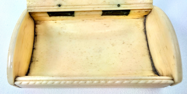 French prisoner-of-war bone snuff box featuring deeply incised Masonic iconography and decorative rope-pattern edging.