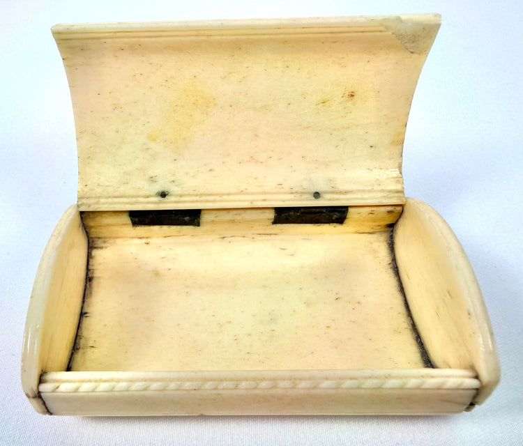 Antique carved bone snuff box with an arched hinged lid, intricate engravings, and a naturally aged patina.
